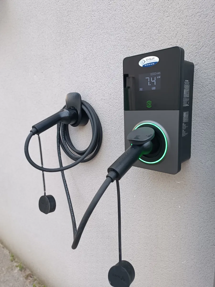 Borne de recharge Autel 7,4 kW avec câble attaché installée par SYSUR sur une façade extérieure