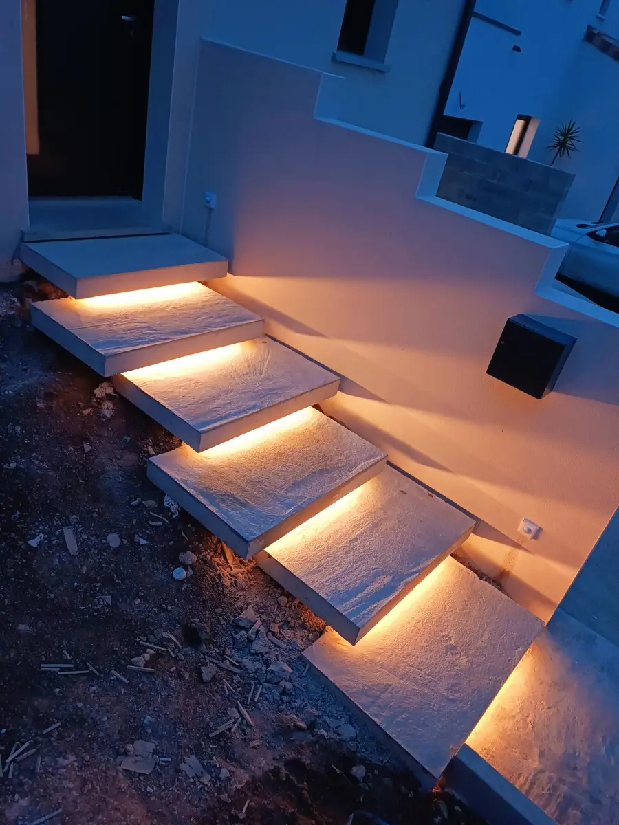 Escalier extérieur éclairé de nuit par des bandeaux LED intégrés sous les marches