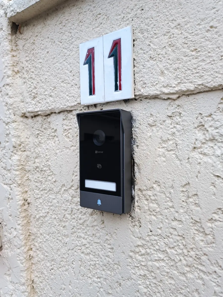 Interphone vidéo noir avec caméra posé par SYSUR sur la façade d'une maison individuelle