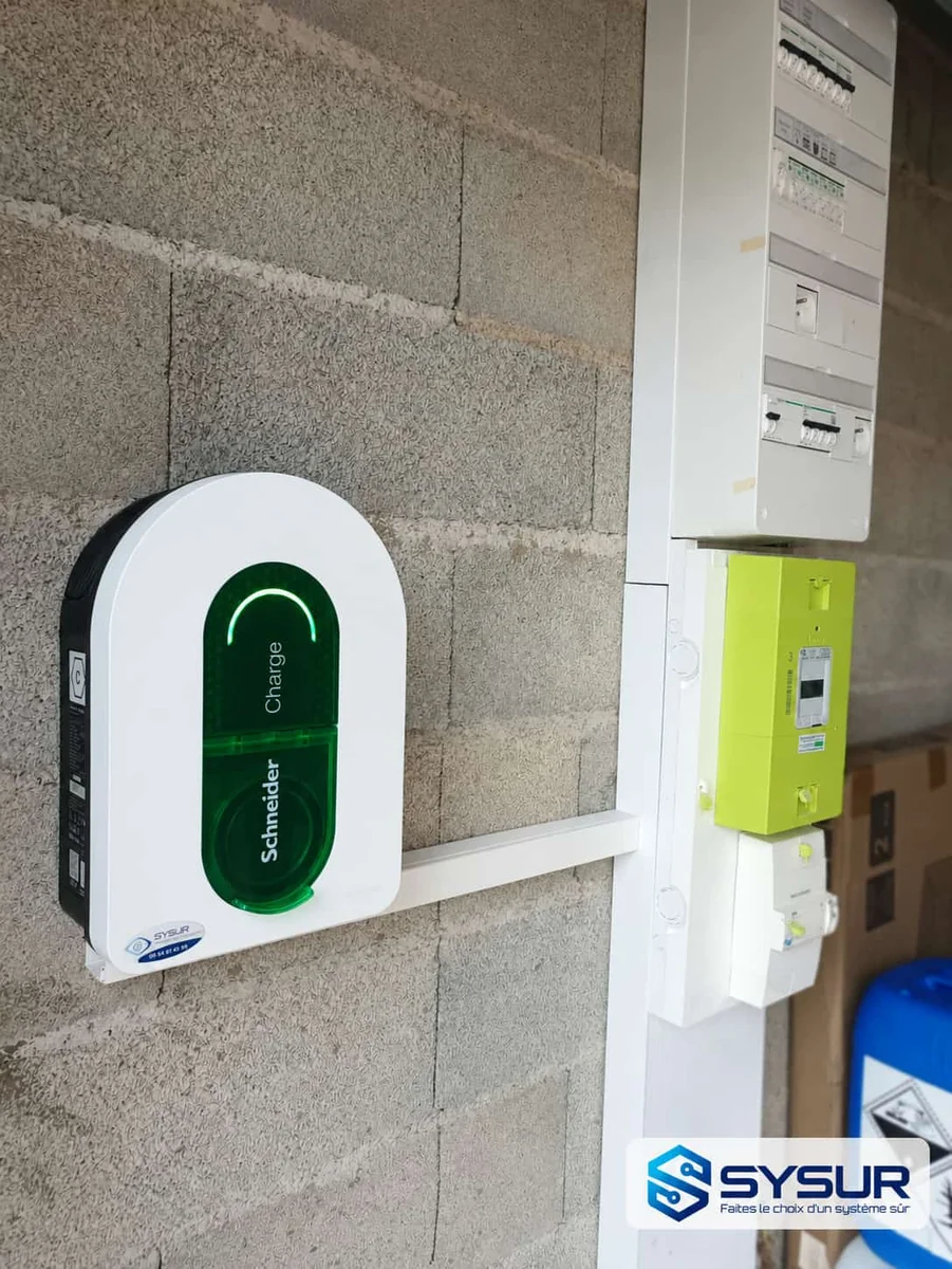 Borne Schneider Charge installée par SYSUR dans un garage, à côté du tableau électrique et du compteur Linky